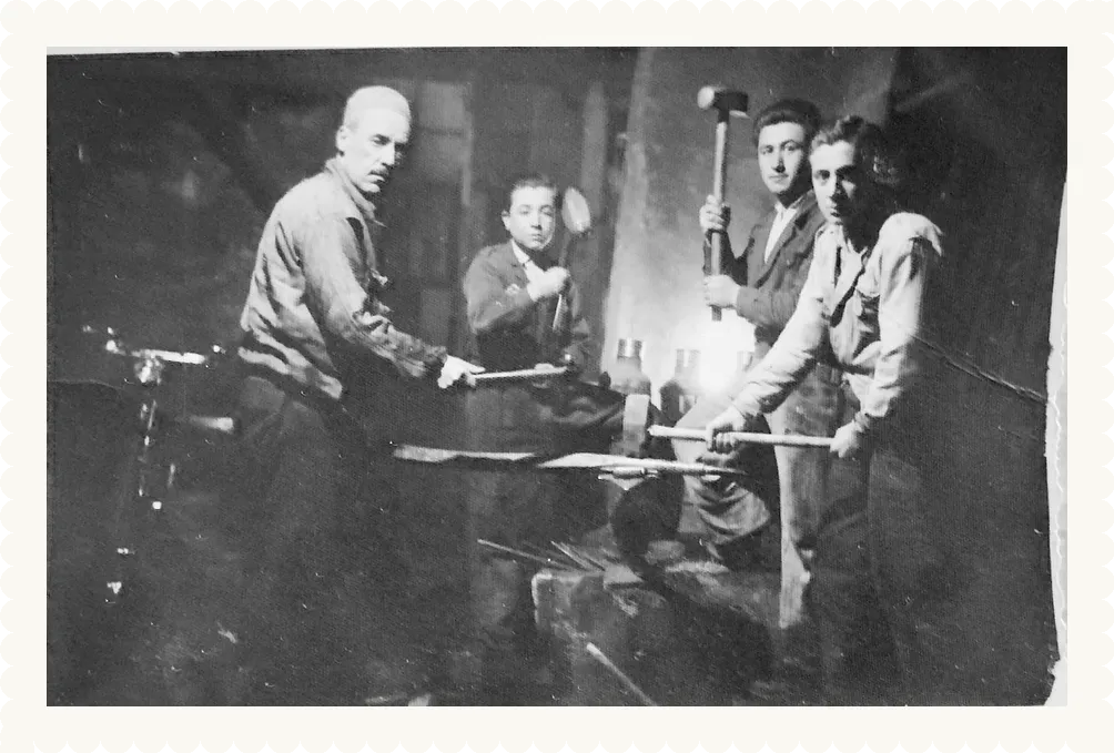 Demirci atölyesinde dört usta, örsün başında. Aile arşivi.